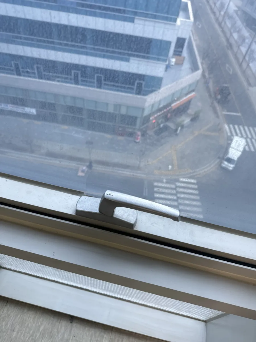 결합부가 헐거워져 흔들리는 창문 손잡이를 살펴보는 모습